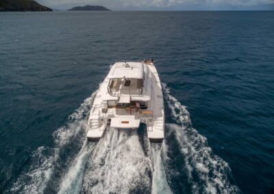 White catamaran cruising on turquoise waters.