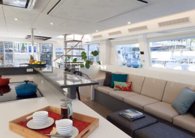 Modern yacht interior with kitchen and seating.