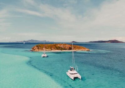 Catamarans anchored near a tropical island.