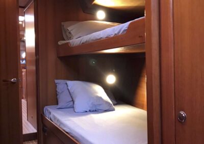 Boat cabin with two bunks and soft lighting.